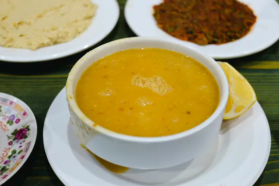 Limon dilimiyle servis edilmiş bir kase mercimek çorbası